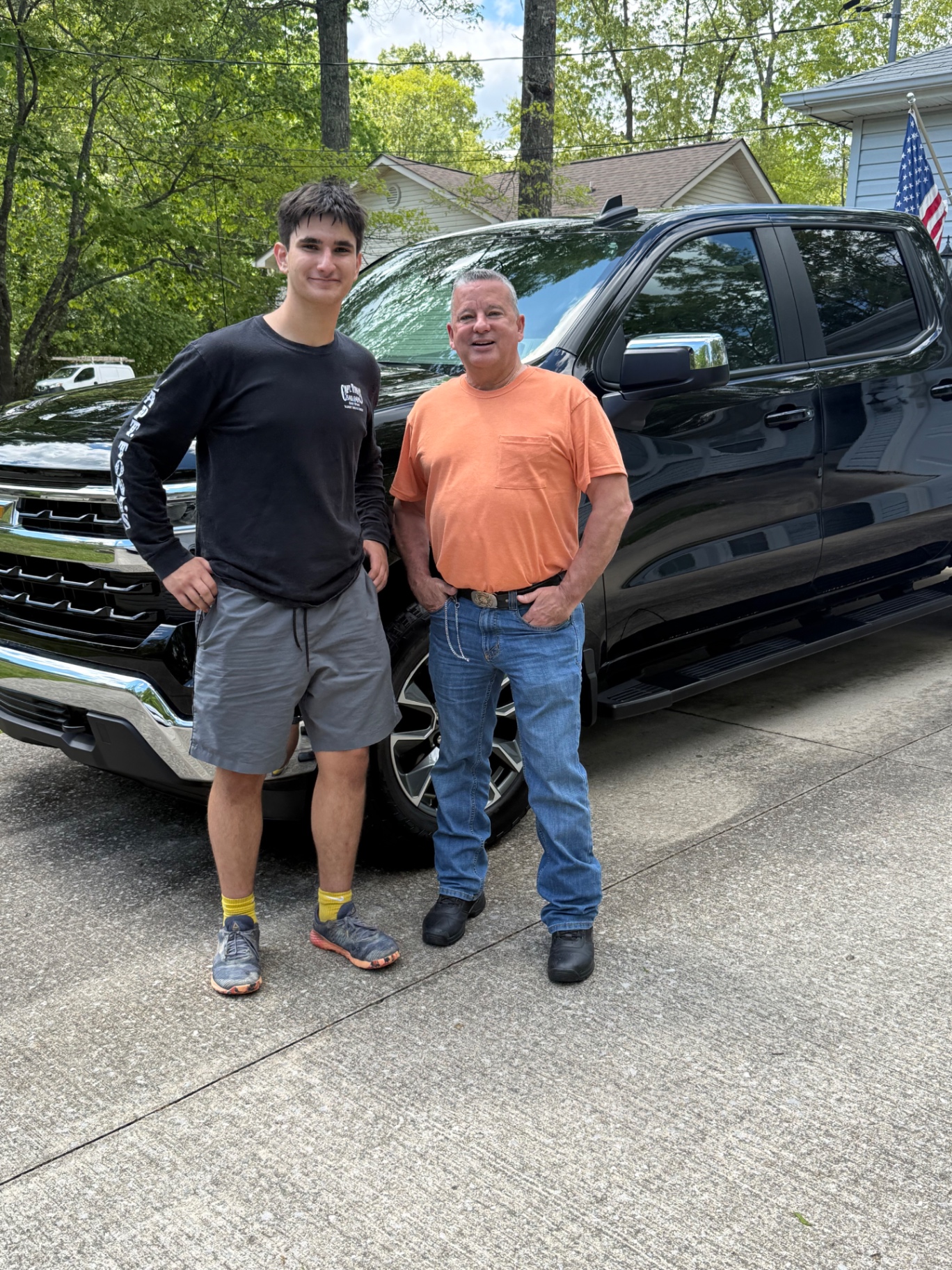 Isaac Most of Cookeville Detailing standing with a happy customer next to a freshly detailed black truck